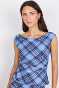 Woman wearing a blue plaid top against a white background
