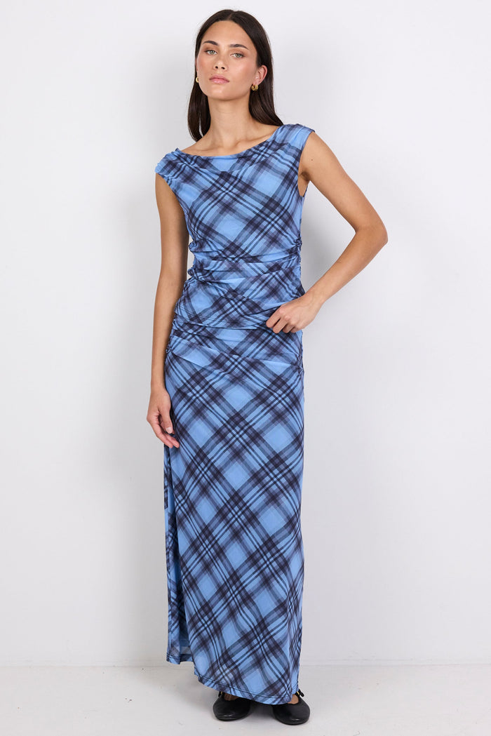Woman wearing a blue plaid top and skirt on a white background