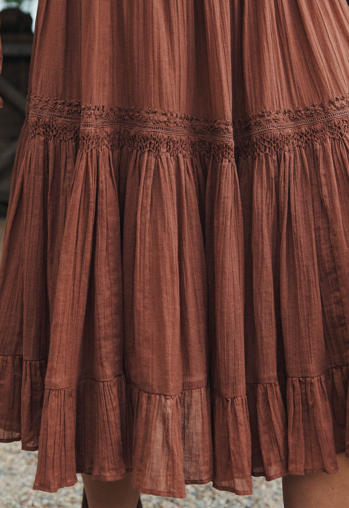 Close-up of Prairie Midi Skirt skirt hem showing crochet trim, shirring detail, and tiered organic cotton frills in brownie