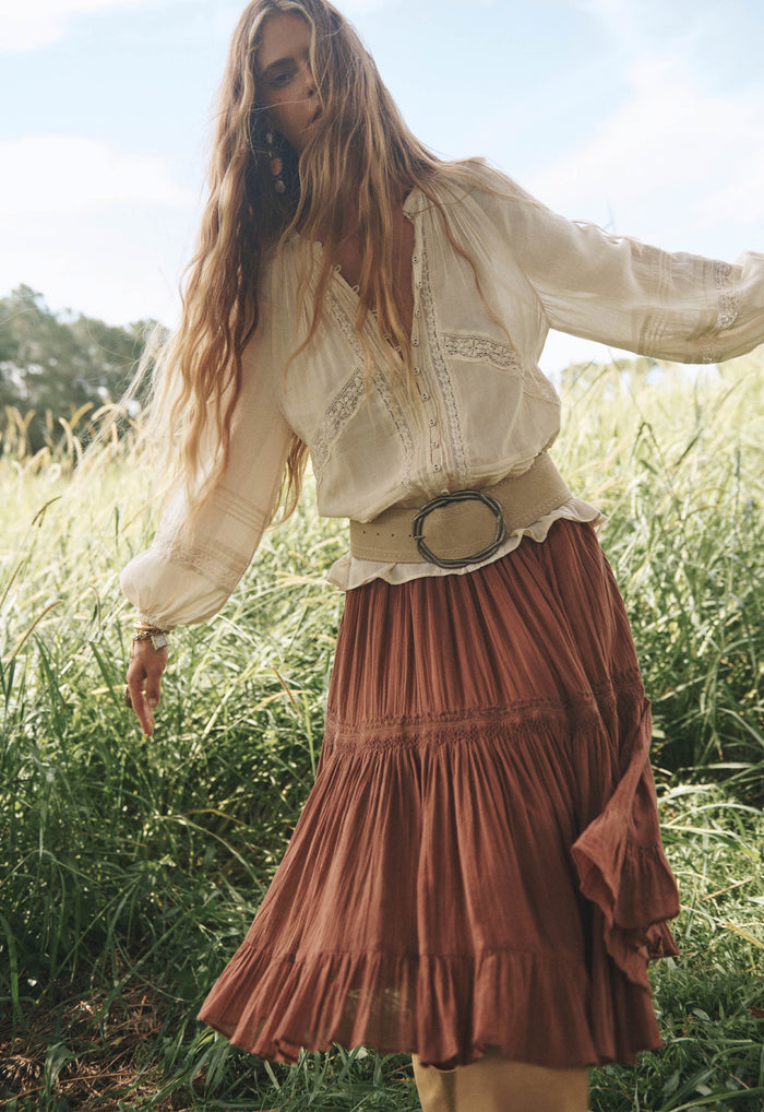 Model wearing Brownie Prairie Midi Skirt, tiered organic cotton with lace trim and hem frill, outdoor field setting