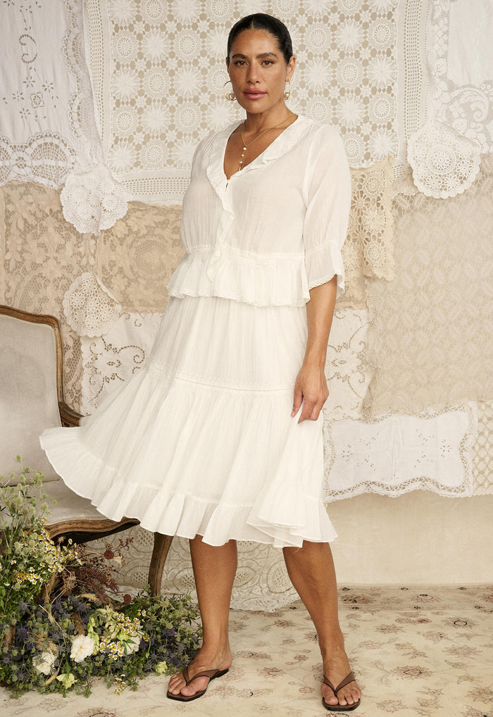 Model wearing Spell Prairie Midi Skirt in Whisper White organic cotton with tiered hem and lace trim, front view