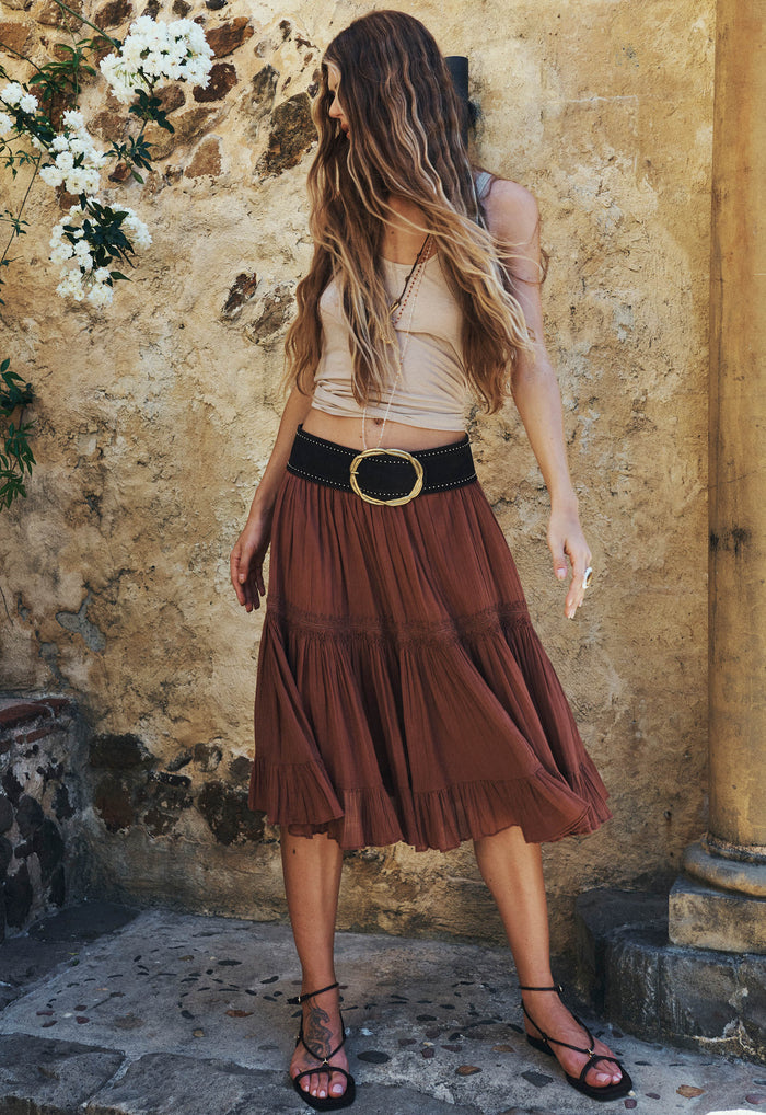 Model wearing Prairie Midi Skirt in Brownie, side view showing tiered organic cotton skirt with lace trim detail