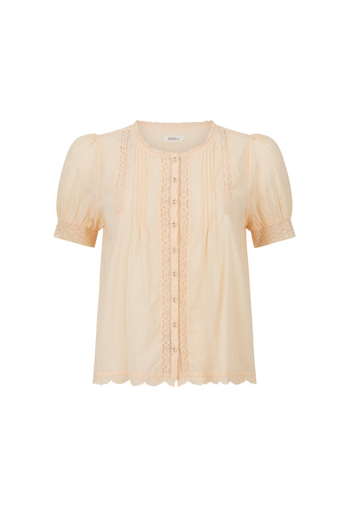 A pale peach short-sleeve blouse with puff sleeves, a round neckline, and vertical lace trim with a button placket, shown on a plain white background.