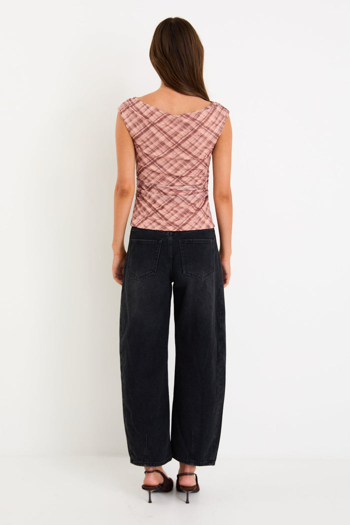 Model wearing a sleeveless blush check mesh top with a scoop neckline and ruched bodice