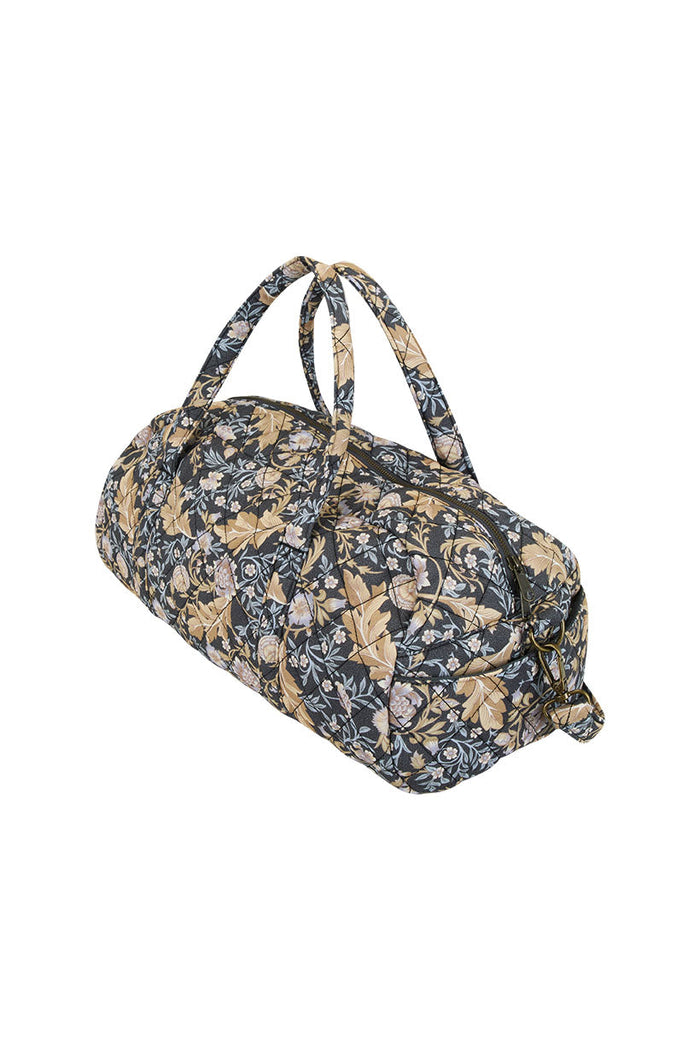 Side angle of quilted duffle bag in Nightshade floral ECOVERO viscose, showing zip closure and dual top handles