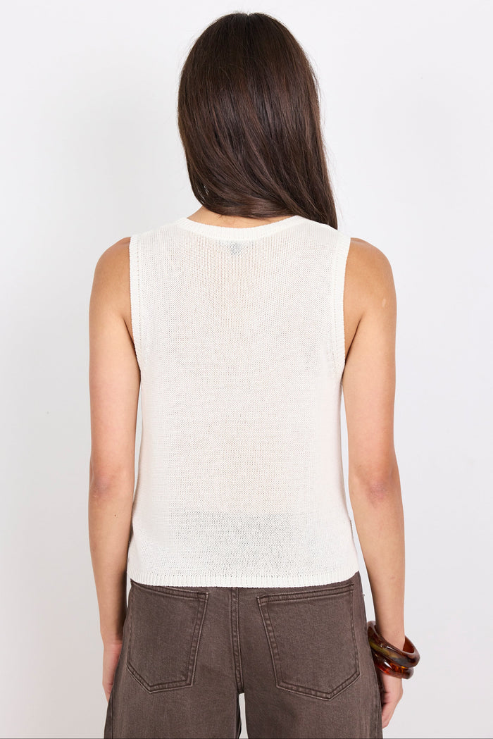 Woman wearing a white knit sleeveless top against a plain background
col_pattern