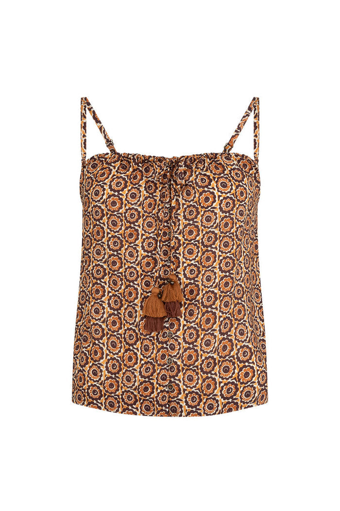 Flat lay of brown floral print cami with front tassel ties, adjustable straps, and button detail on white background