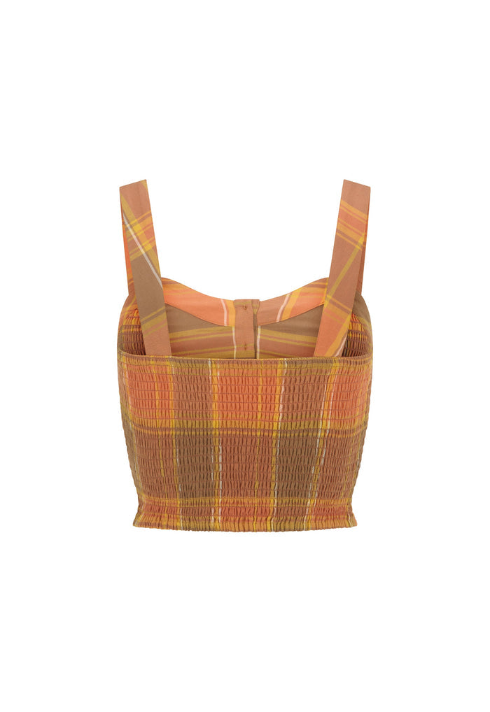 A cropped knit top with wide shoulder straps, featuring a smocked front panel and a plaid pattern in orange, brown, yellow, and beige, shown against a plain white background.