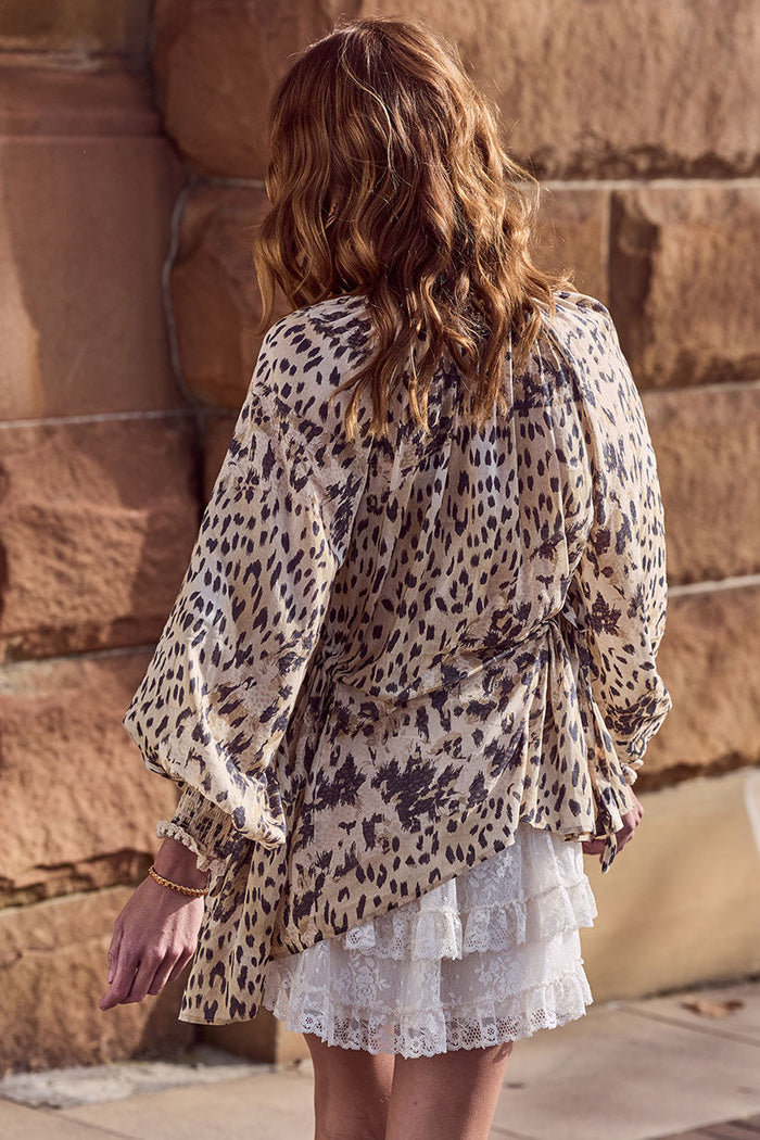 Back view of Snow Leopard Asymmetric Blouse showing asymmetrical hem, shirred cuffs, and side tie detail