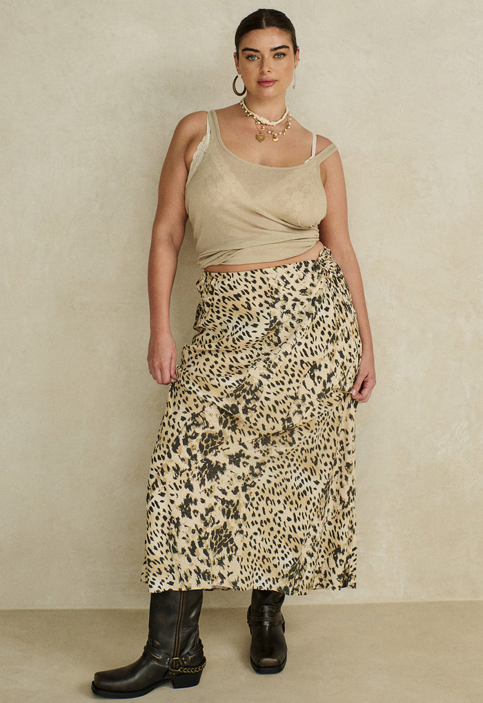 Model front view wearing Snow Leopard Bias Maxi Skirt, styled with beige tank and black cowboy boots