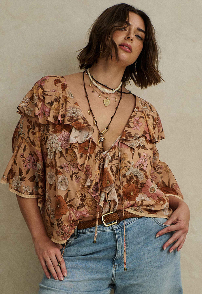 Rose Quartz floral blouse flat lay showing front ties, neck ruffle, lace trim, and shaped hem detail