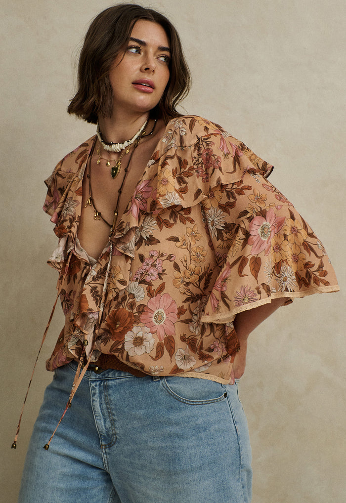 Model wearing Stealing Beauty blouse, front ties and lace-trim hem visible, floral organic cotton blend