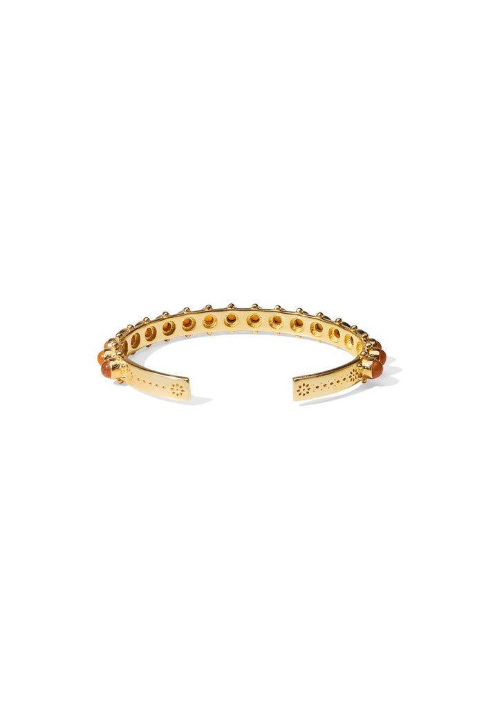 Underside of gold cuff showing perforated brass band, floral-etched open ends, and carnelian stone settings