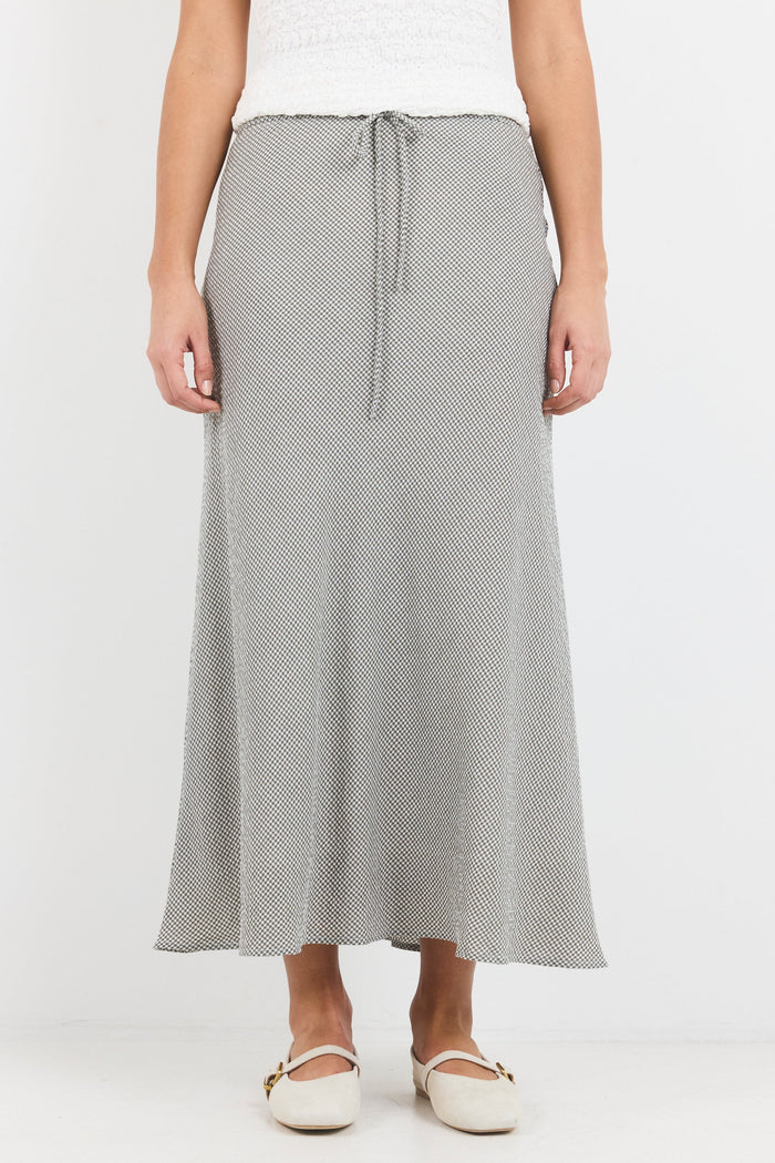 Person wearing a gray patterned skirt on a white background