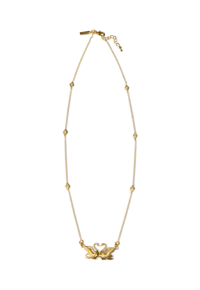 Swan Lake Necklace gold flat lay, dual swan pendant with crystal diamond stations on 22k gold-plated chain, lobster clasp