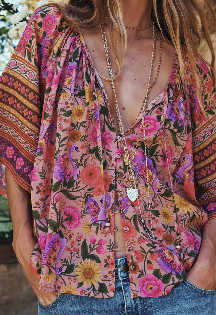 Front close-up of a model wearing Swan Lake blouse, showing V-neck, button opening, and beaded neck tie detail