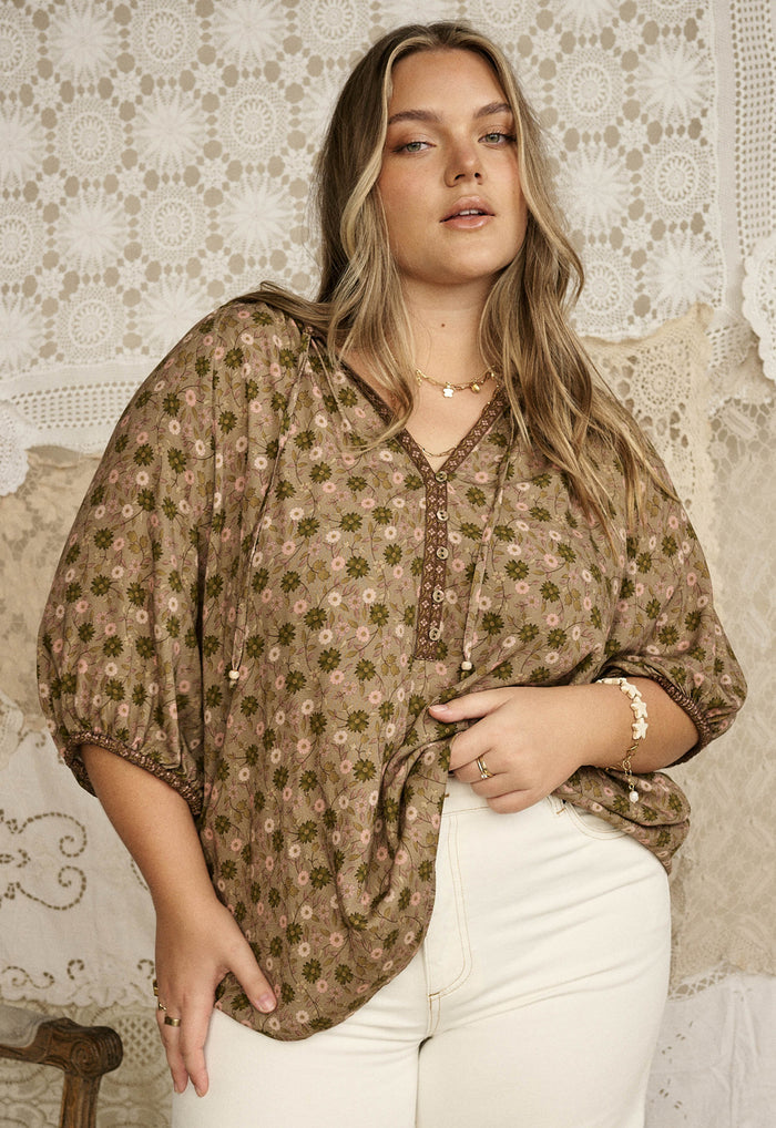 Model wearing sage floral ECOVERO viscose blouse, front view showing contrast border trim and elastic sleeve hem