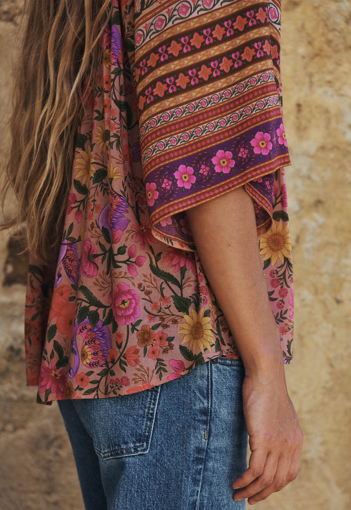 Side view of floral blouse showing mixed border print sleeve and hip-length hem in pink lilac rose