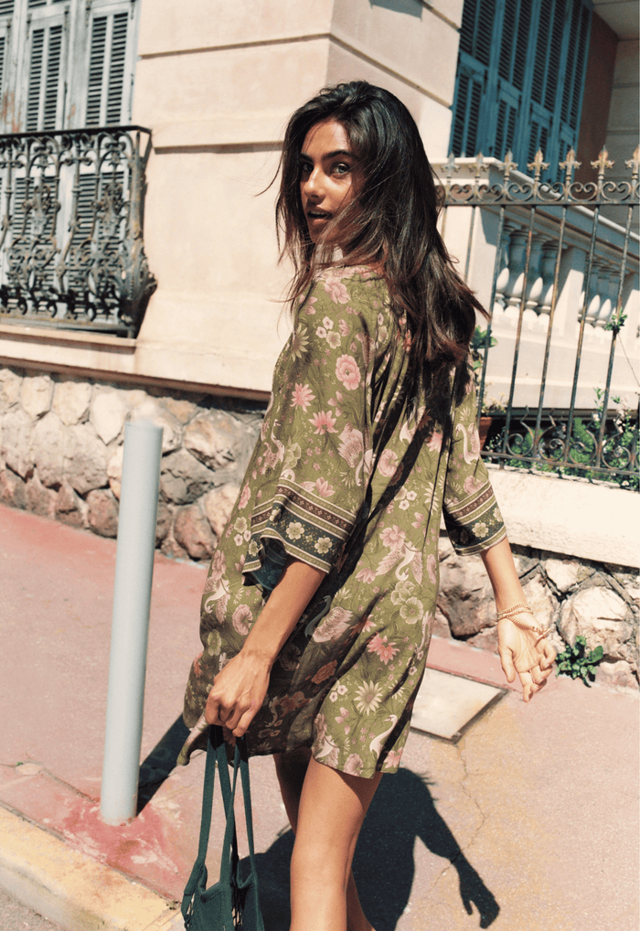 Model wearing Swan Lake Tunic Dress in Sage, three-quarter view showing raglan sleeves with border print cuffs