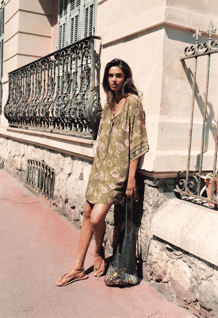 Model wearing Swan Lake Tunic Dress in Sage, front view showing self-tie neckline and raglan sleeves, styled with sandals