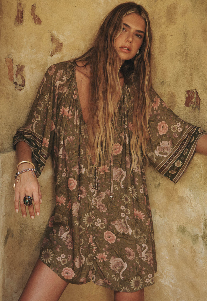 Front-facing model shot of a model in sage Swan Lake Tunic Dress, showing button-through front and self-tie neckline