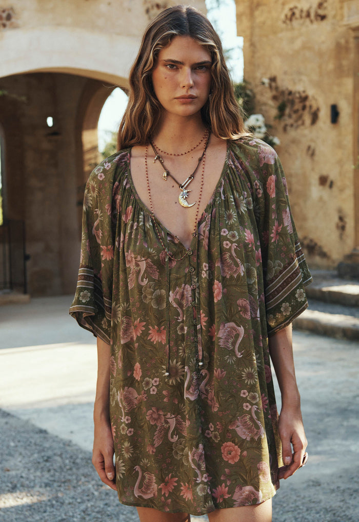 Front-facing model shot of sage Swan Lake Tunic Dress showing button-through front and raglan sleeves with border print cuffs