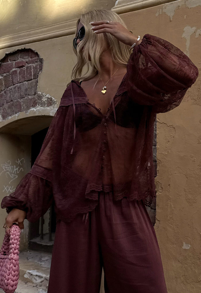 Model wearing Teodora Lace Blouse in Fudge, front view showing sheer lace, pintucks, neck ties and button front