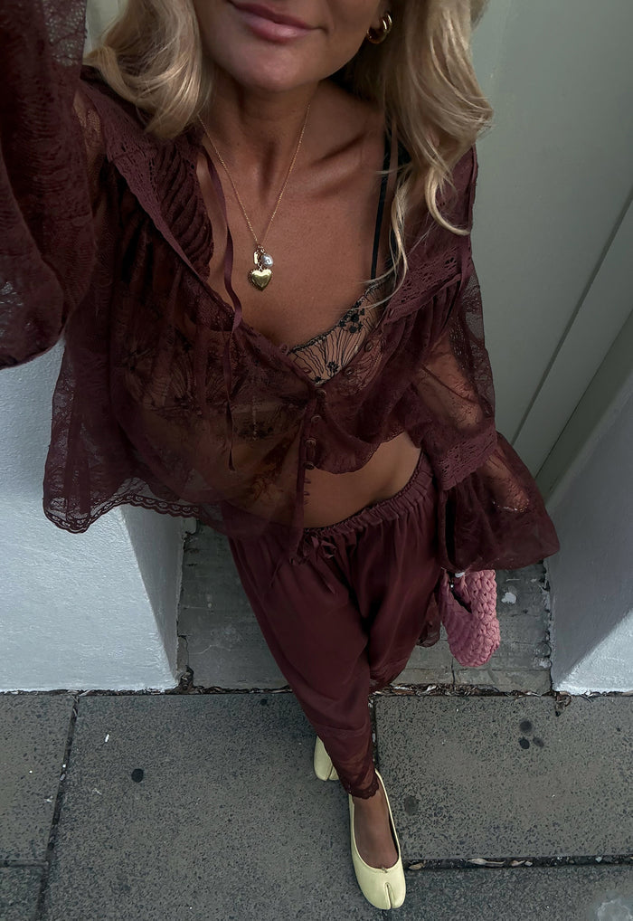 Model wearing Teodora Lace Blouse in Fudge, front-open view showing neck ties, lace inserts, and ruffle cuffs