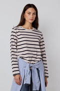 Woman wearing a striped sweater and blue jeans with a white background