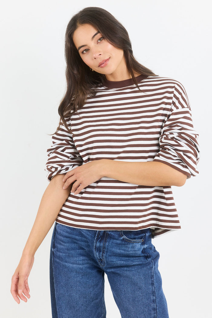 Woman wearing a striped shirt and jeans on a white background