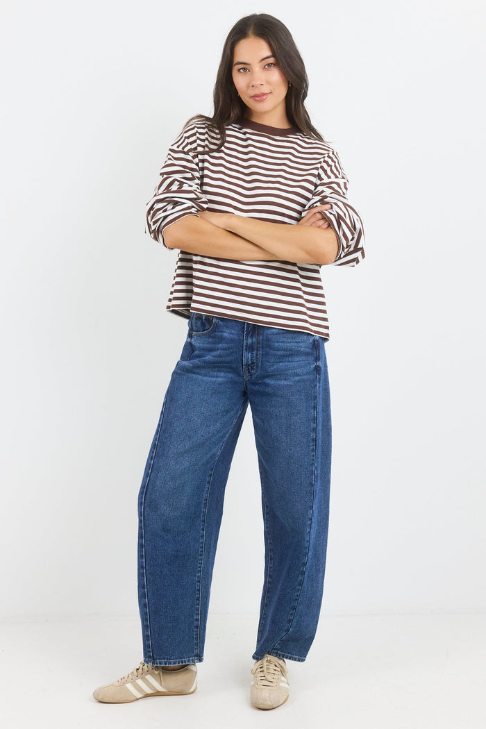 Person wearing a striped shirt and blue jeans on a white background