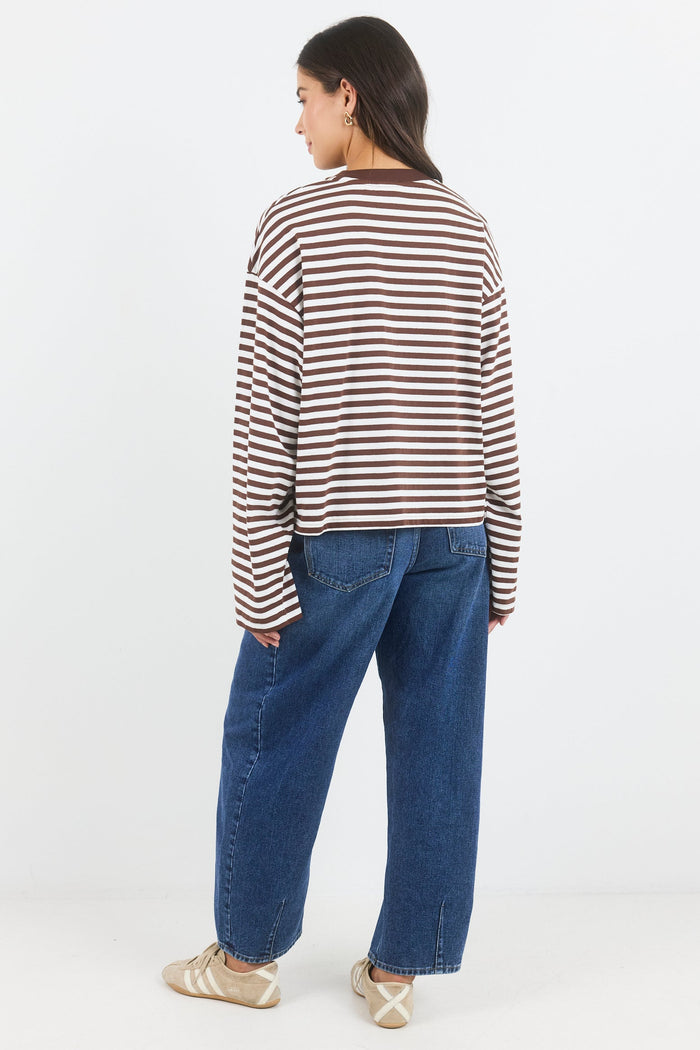 Person wearing a striped shirt and blue jeans on a white background