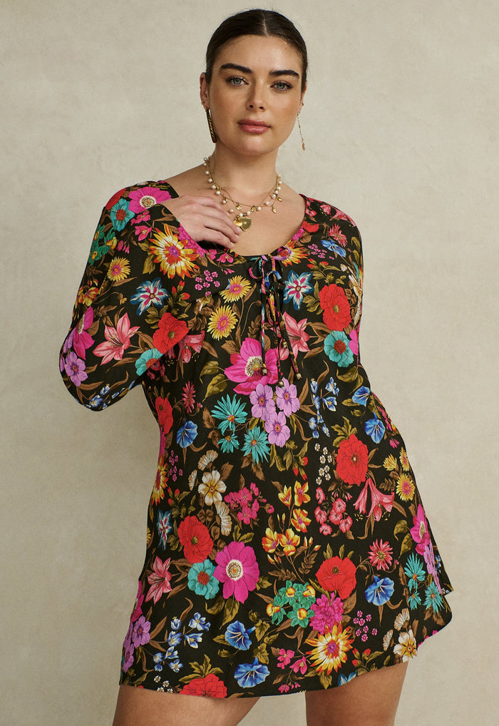 Flat lay of Valley of the Dolls Bias Mini Dress in Onyx, showing bold floral print and front tie detail