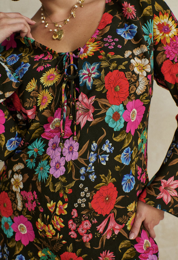 Close-up of V-neckline with self-tie front and custom Spell trim on ties, multifloral ECOVERO viscose