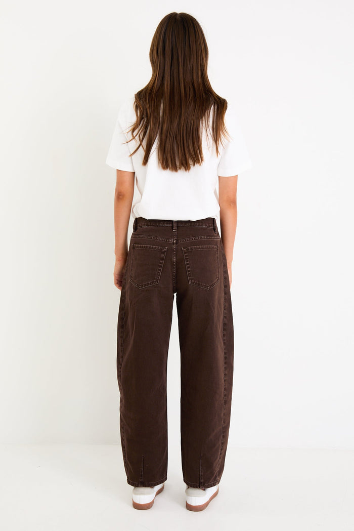 Woman wearing a white top and brown pants on a white background.
col_pattern