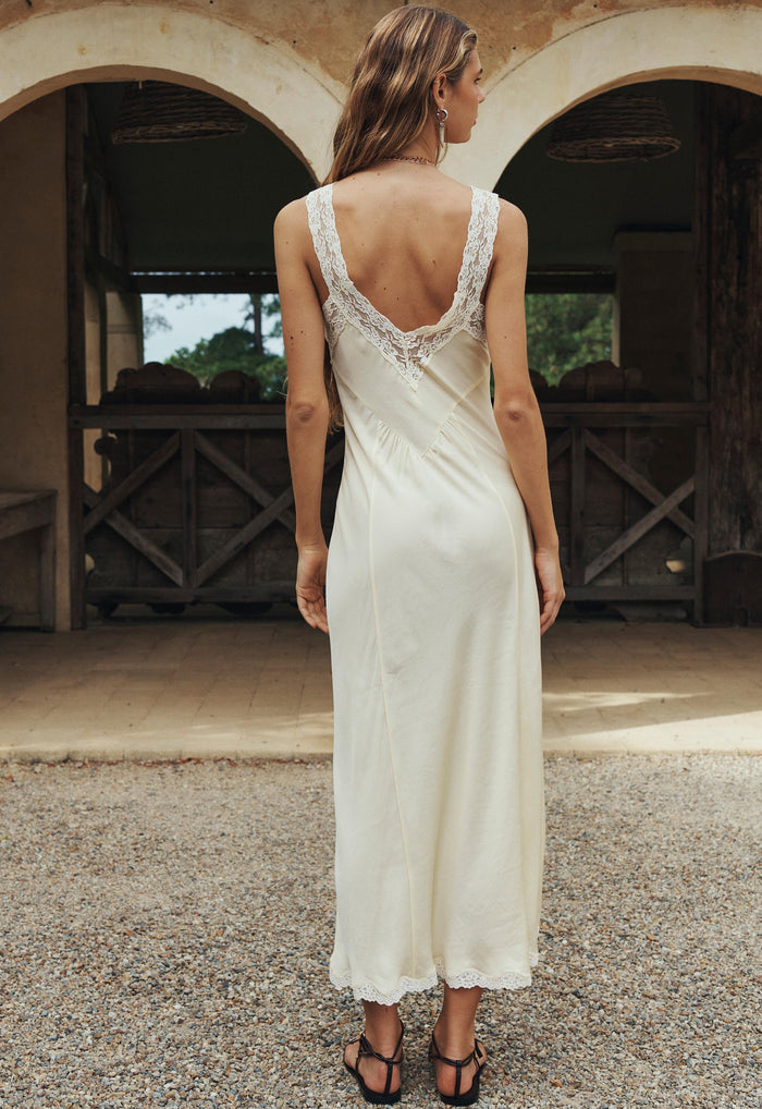 Back view of a model in buttermilk TENCEL slip dress, lace-trim straps and low scoop back, maxi length