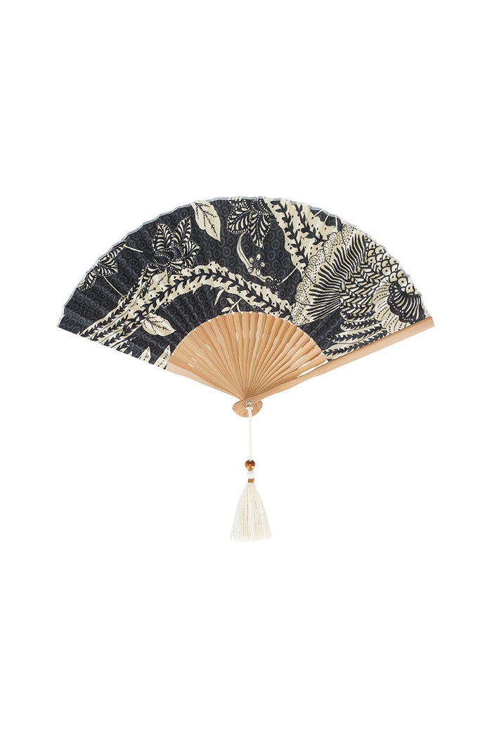 Spell Volcano Goddess Handheld Fan in Coal, black floral TENCEL print with bamboo handle and cream tassel