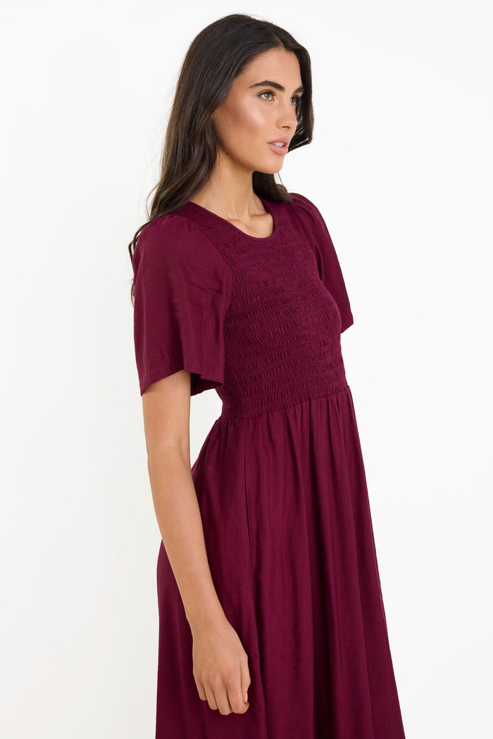 Woman wearing a burgundy dress on a white background