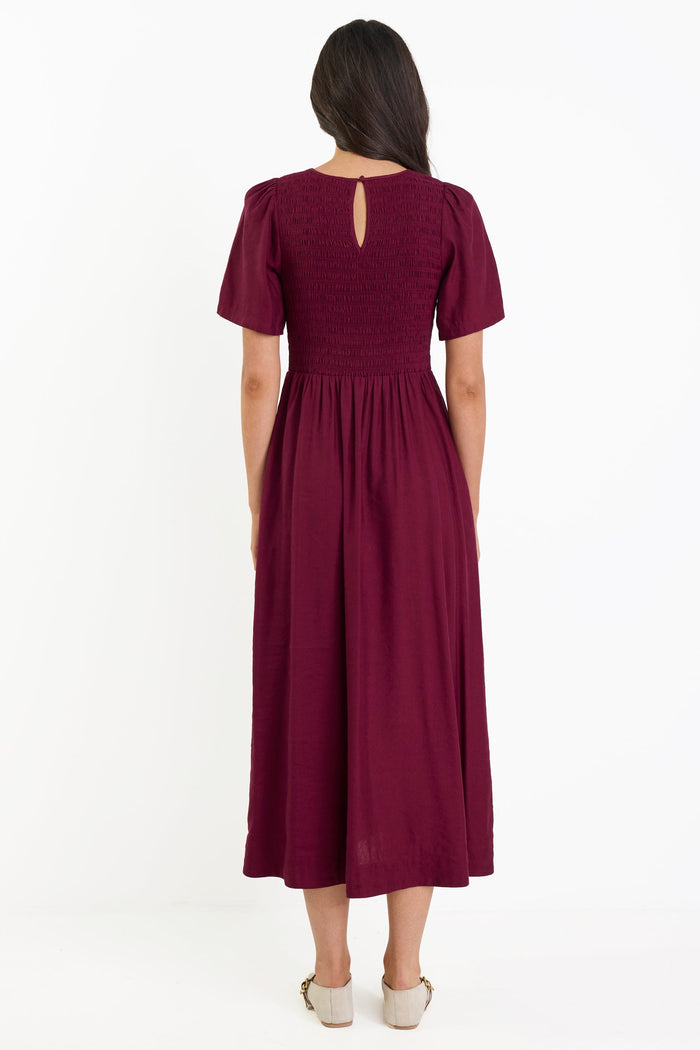 Woman wearing a burgundy dress on a white background