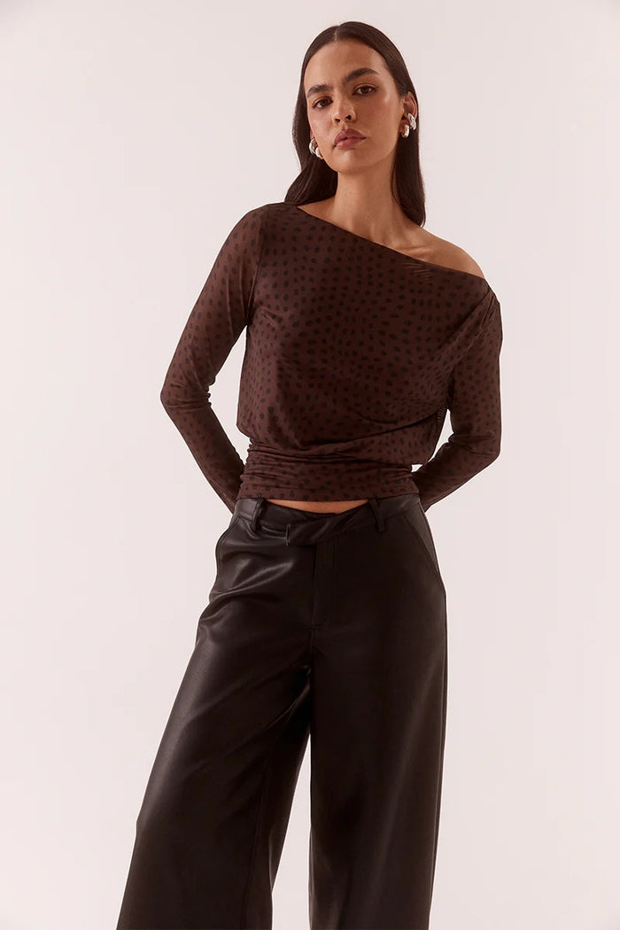 Woman wearing a brown off-shoulder top and black pants against a white background
@col_Shade